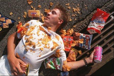A person lying on the ground with chips and chips
Description automatically generated